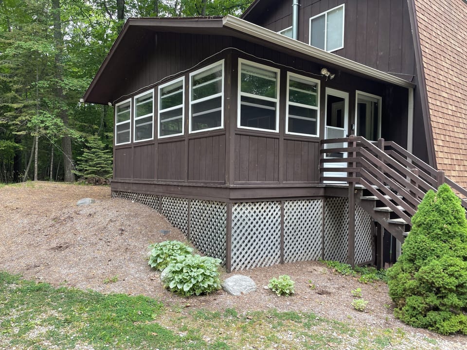 View of exterior of Sunroom, surrounded by woods on all sides.