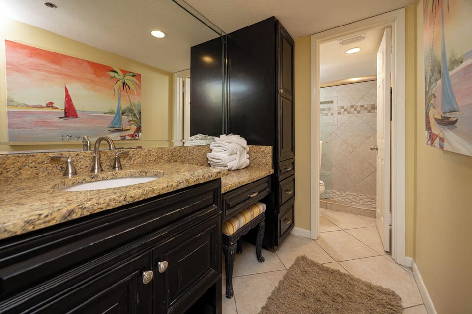 Experience an elegant master bath featuring a spacious vanity, decorative art, and a relaxing walk-in shower