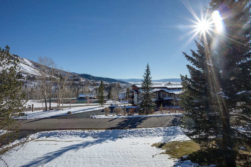 Stunning winter mountain landscape with snow-covered peaks and bright sunshine illuminating the peaceful neighborhood setting.