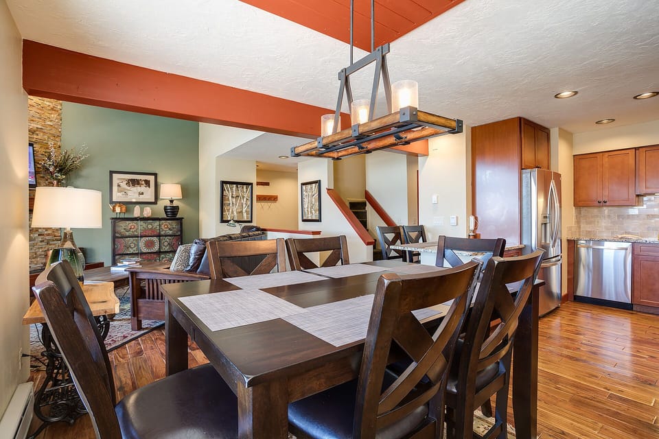Gather around your spacious dining table where warm wood tones and modern lighting create the perfect setting for memorable meals together.