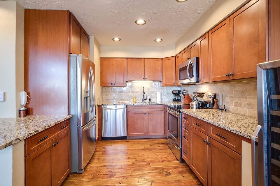 Your gourmet kitchen features rich wood cabinetry, granite countertops, and premium stainless steel appliances for memorable meal preparation.