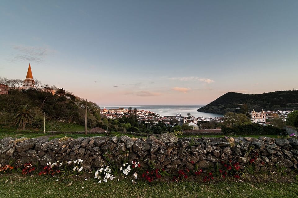 Vista da cidade e oceano ao pôr do sol
