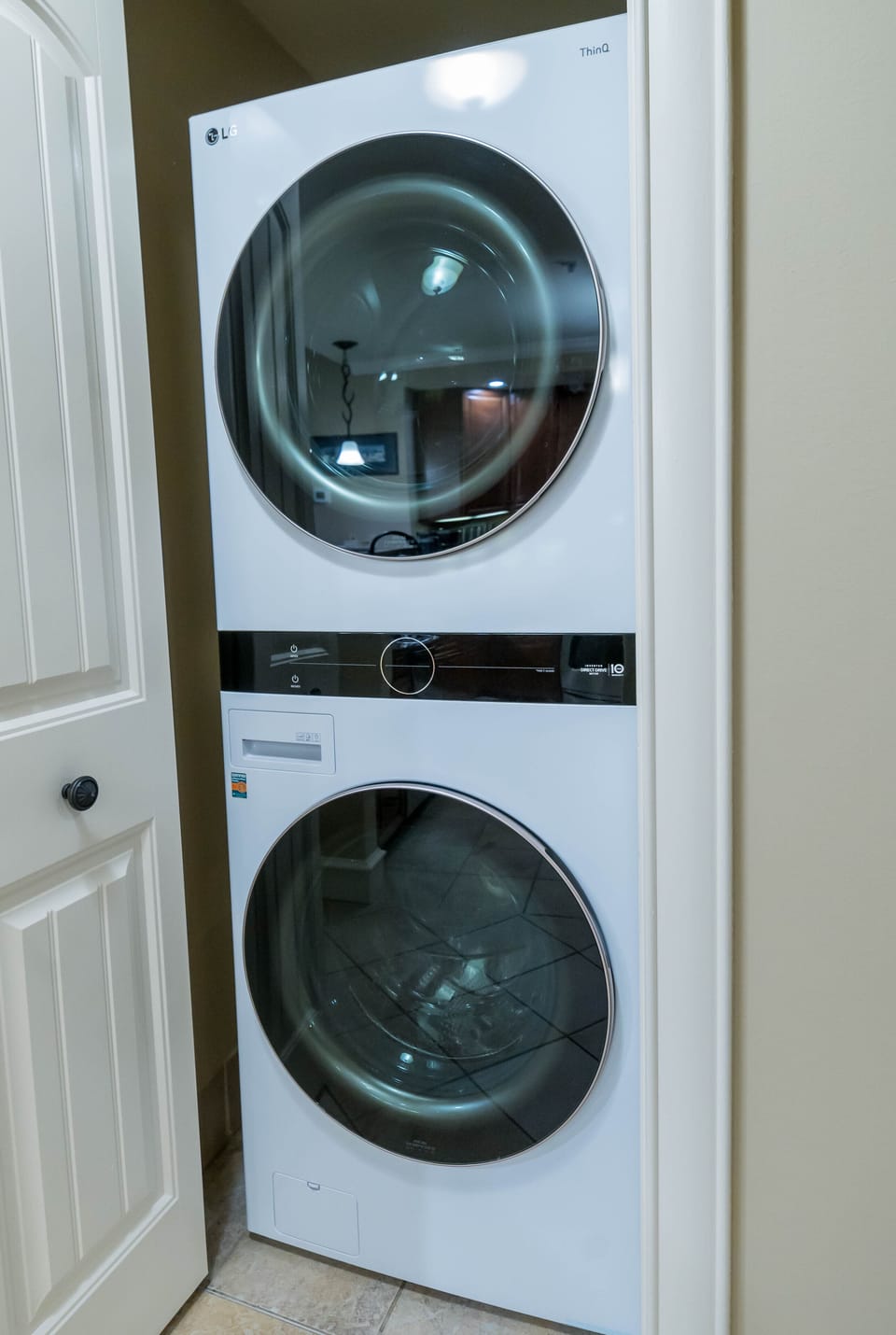 Full sized front load washer and dryer across from kitchen