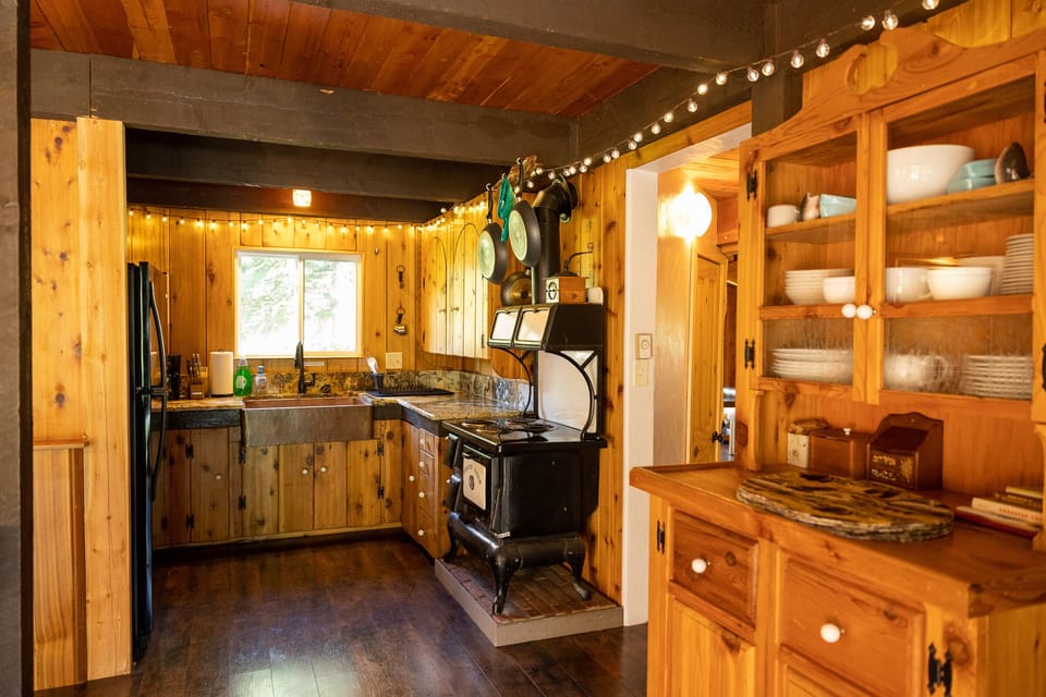 Kitchen with full-sized refrigerator, copper sink, oven, and granite countertops