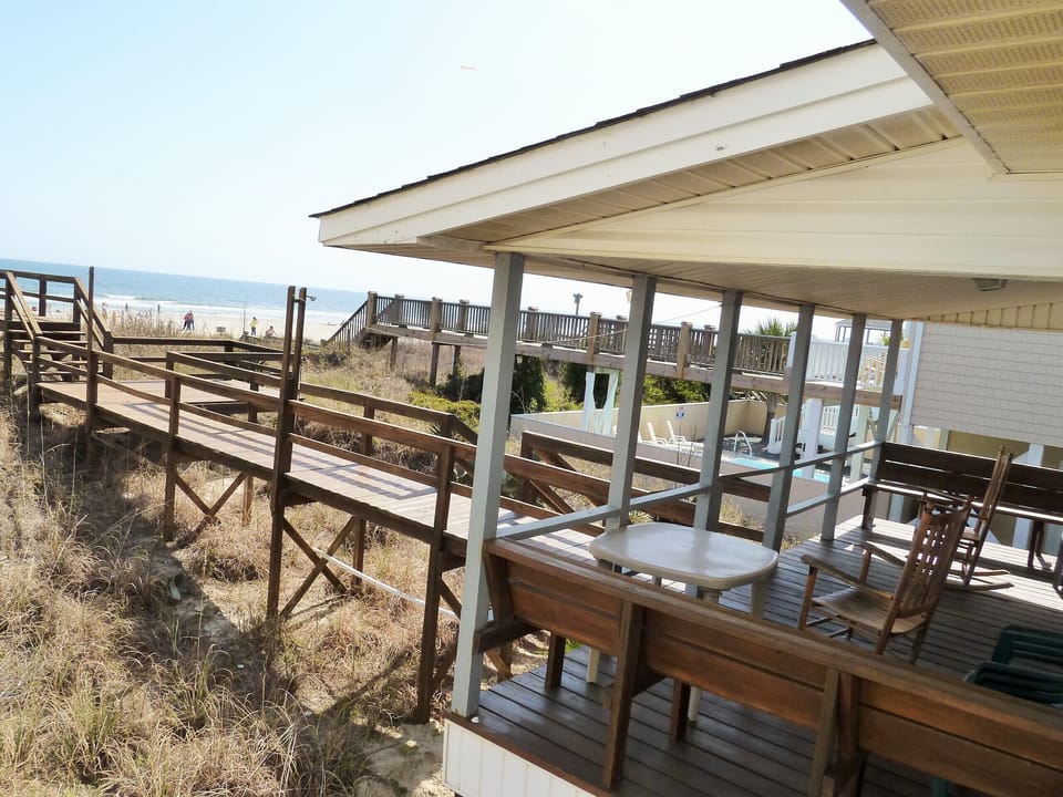 Covered porch with benches and rocking chairs.