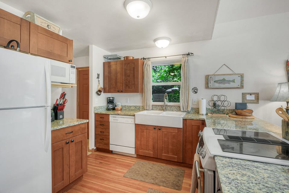 A bright, open kitchen with all the appliances - full-sized fridge, dishwasher, microwave, stove/oven