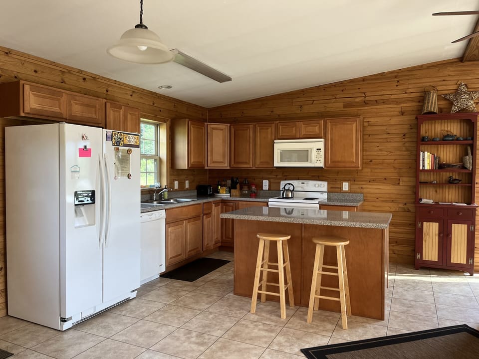 Kitchen area with island, Microwave, dishwasher, stove, and fridge.