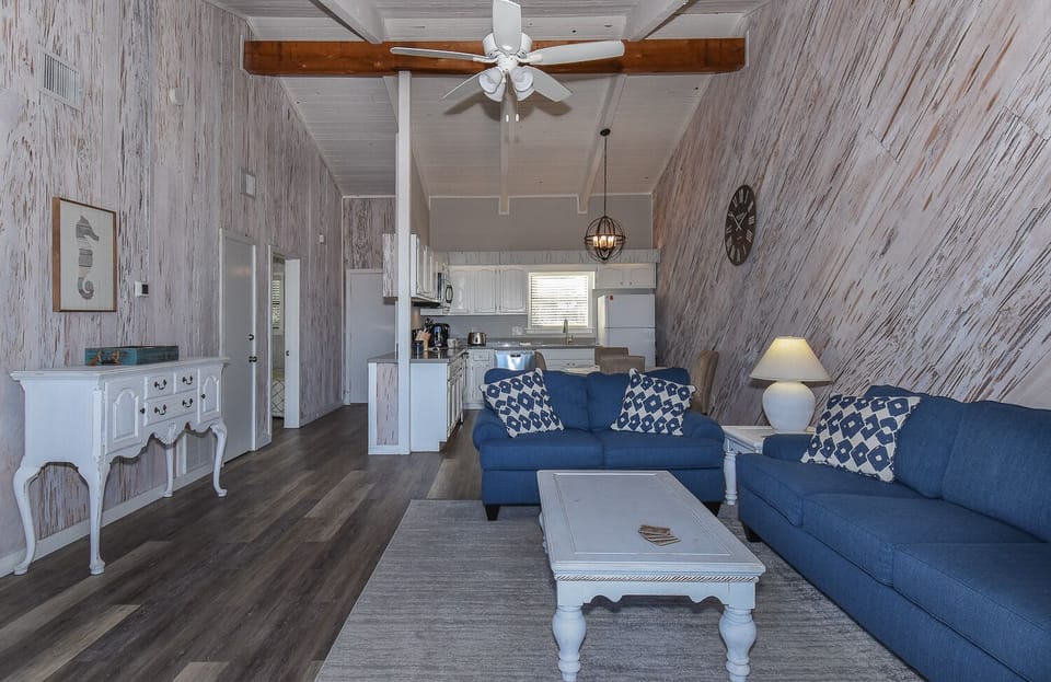 Living room with blue seating and white tables