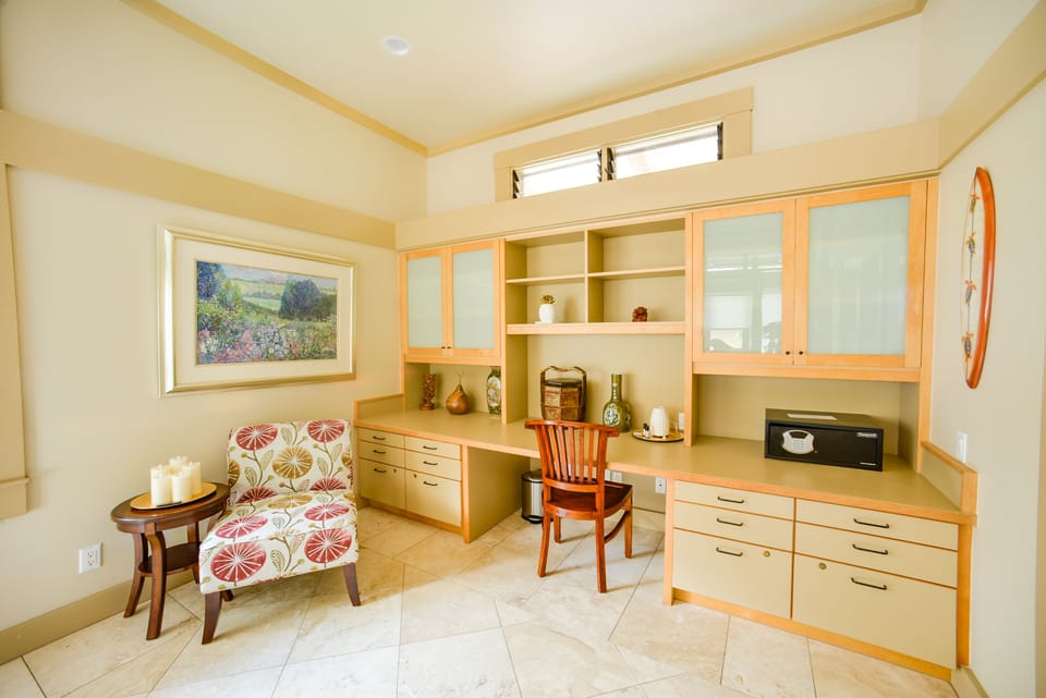 The second bedroom has a desk and a soft chair.  Two original oil paintings.