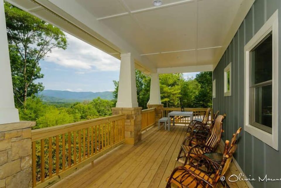 Rocking chairs on a huge covered proch with view and dining.