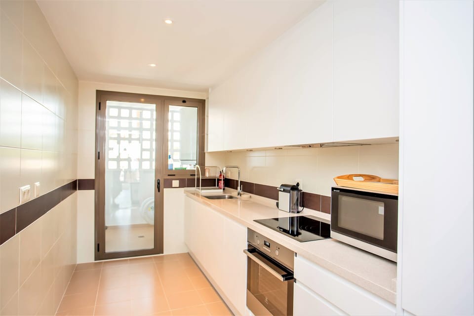 Kitchen with dishwasher, fridge, mirco, coffee machine and lots of pots and pans