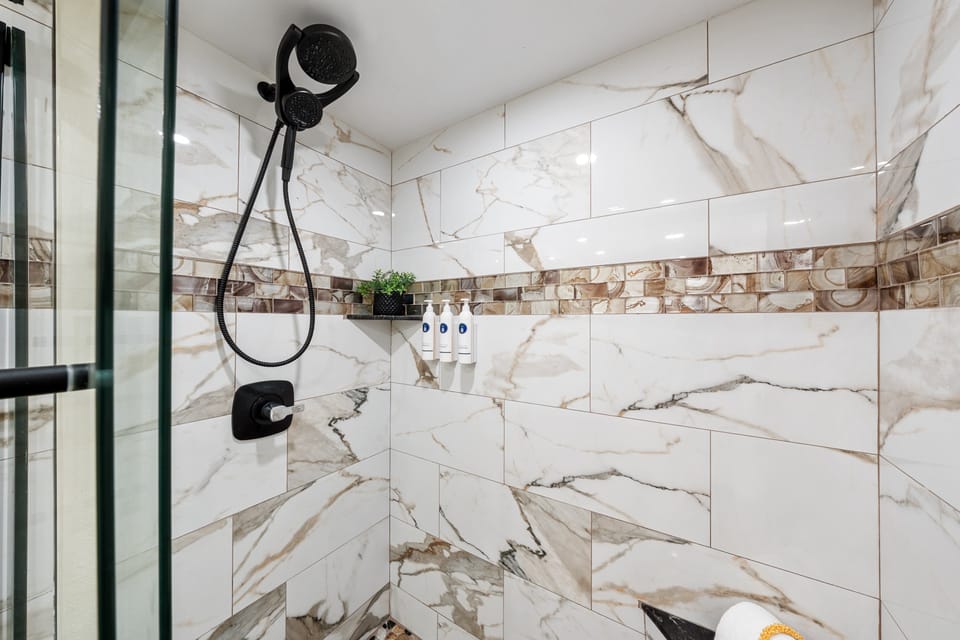Refresh in the updated walk-in shower with modern tile and glass enclosure.