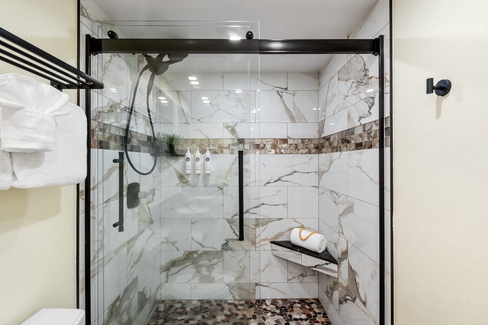 Enjoy the newly updated shower featuring stylish tile and glass enclosure.