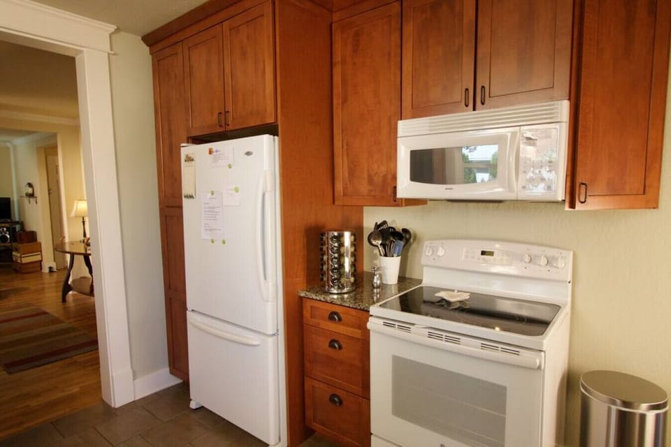 Kitchen with refrigerator, microwave, oven, and spice rack