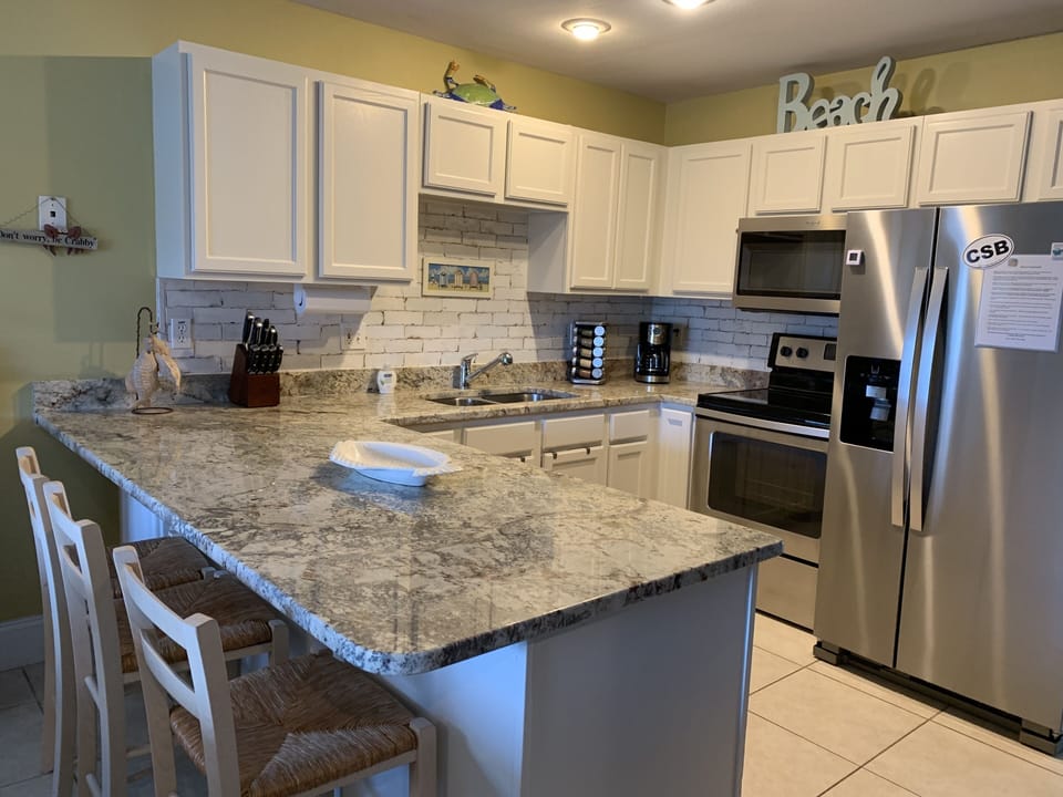 Kitchen with Granite Countertops, Tile backsplash and Stainless Steel Appliances