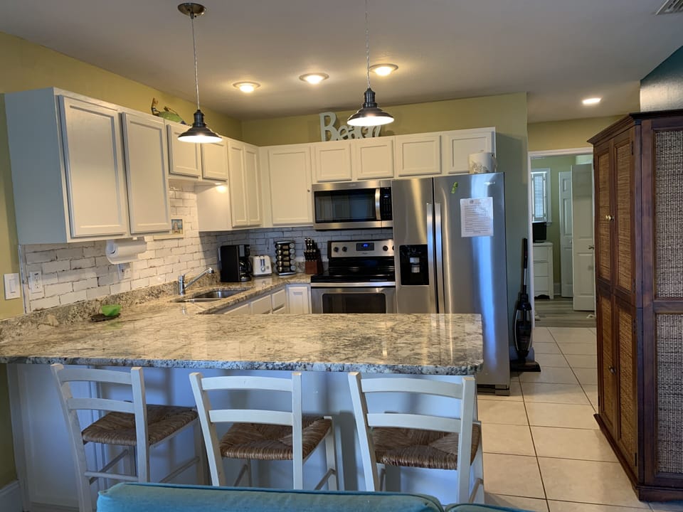 Kitchen with Granite Countertops, Tile backsplash and Stainless Steel Appliances
