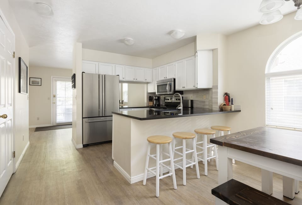 Kitchen features breakfast table with seating for 4 plus bar with 3 stools