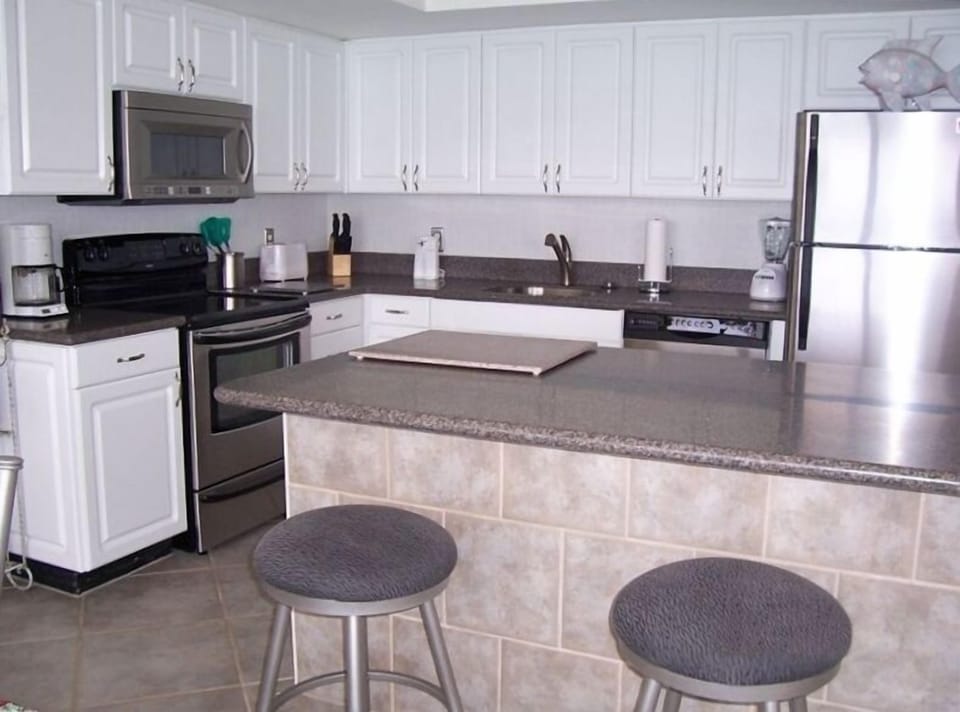 Kitchen with three bar stools. 