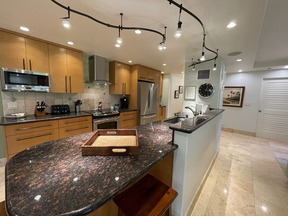 updated modern kitchen with a island and 2 bar stools