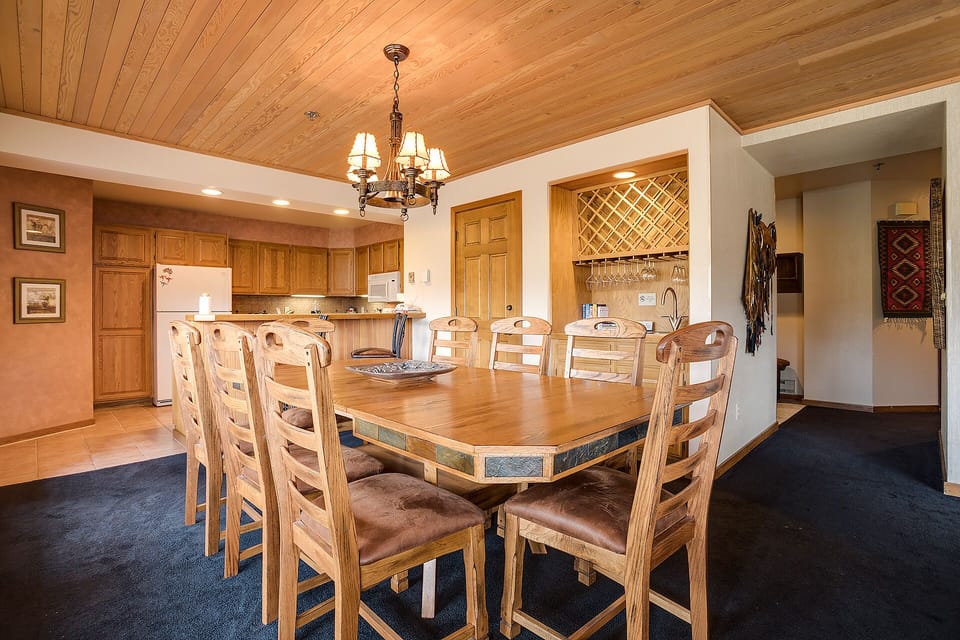 Gather around this handcrafted wooden table where your group will share memorable meals under the warmth of rustic elegance.