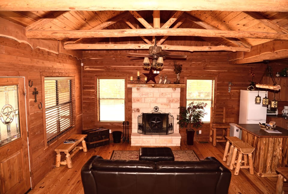 The cozy living area, exposed cedar beams and local limestone fireplace.