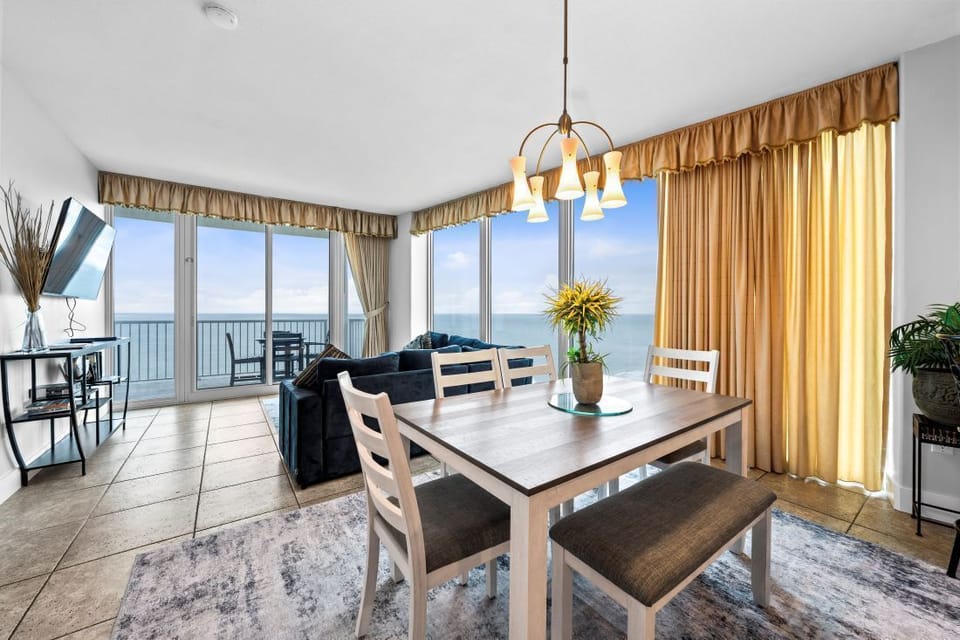 Your bright dining area offers stunning sea views while you enjoy meals with golden curtains framing endless ocean horizons.