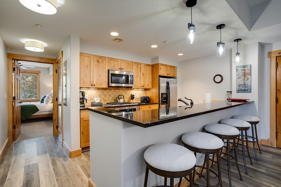 Gather with friends at your spacious kitchen island featuring granite counters, modern appliances, and stylish pendant lighting for memorable meal prep moments.
