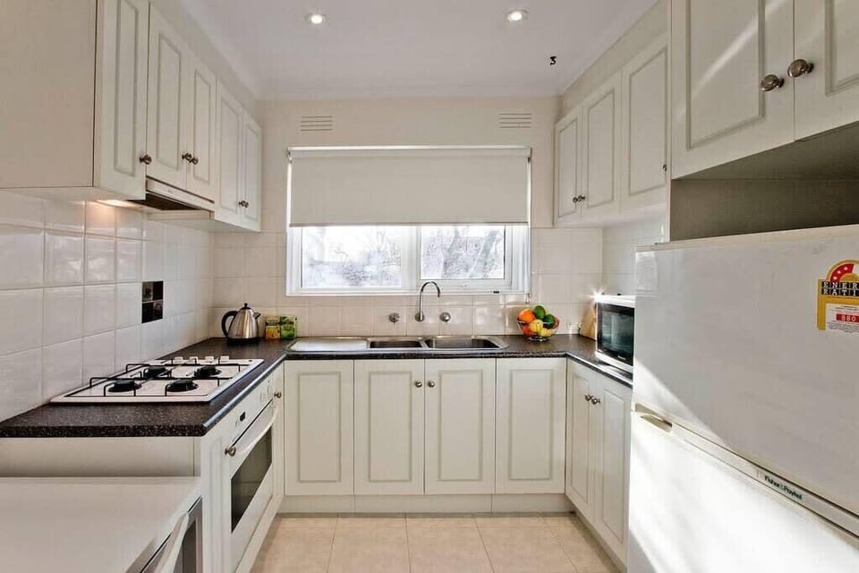 Kitchen has 4 burner gas cooktop with large family size fridge
