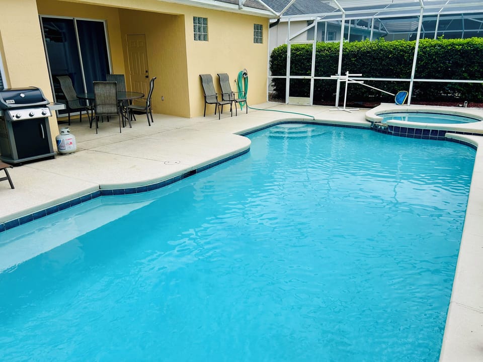 View of pool, spa, and gas grill