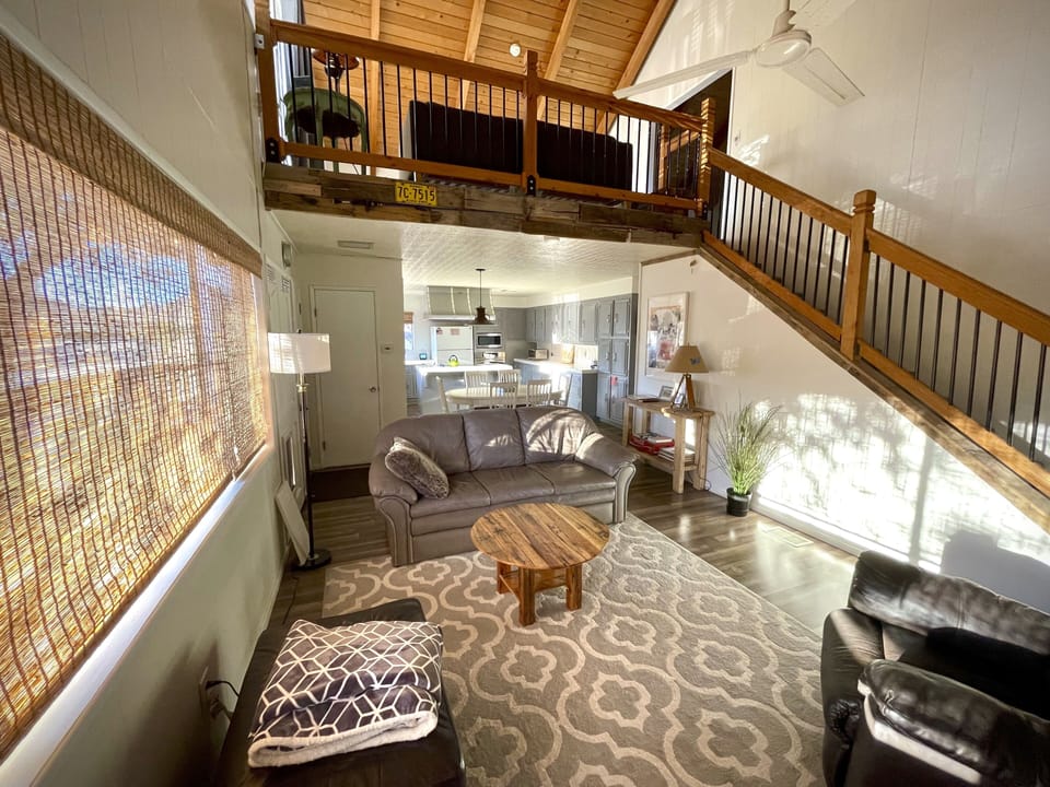 Living room looking towards dining and kitchen areas & stairs to loft/master bed