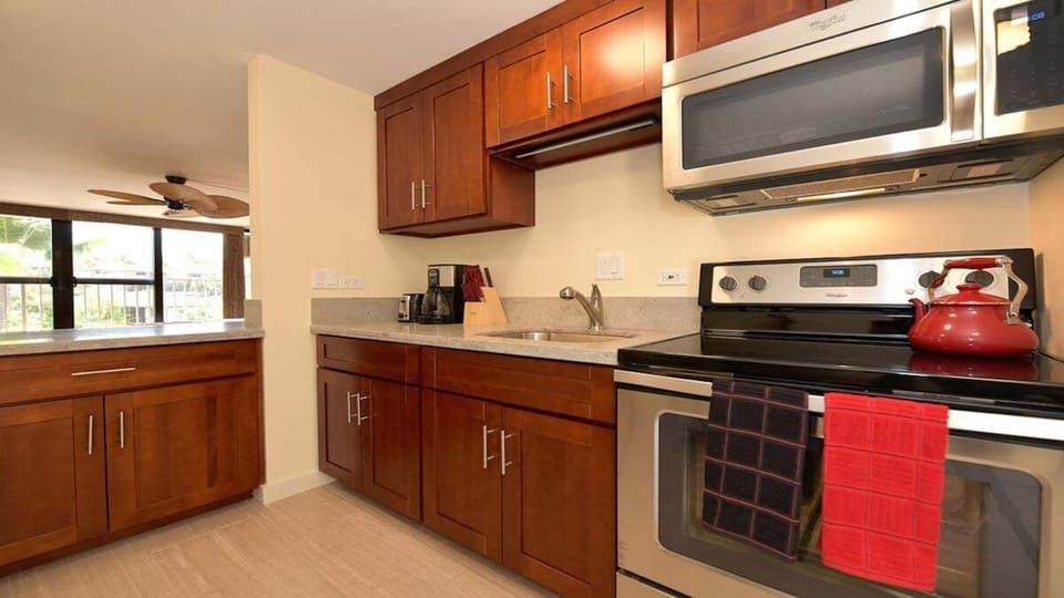 Compact yet elegant kitchen with stainless steel accents and natural wood tones for a warm, inviting feel