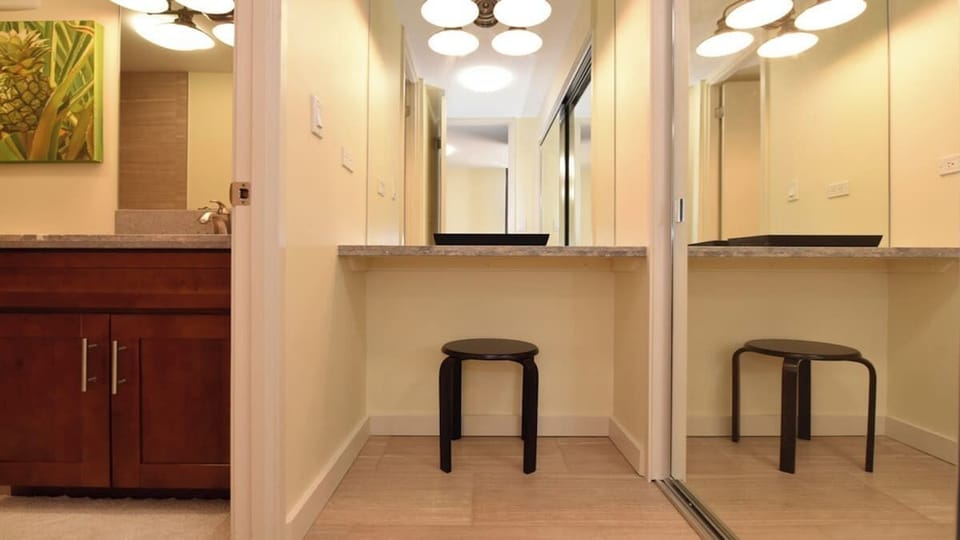 Well-lit vanity corner with chic lighting fixtures and a mirror that enhances the airy feel of the spac