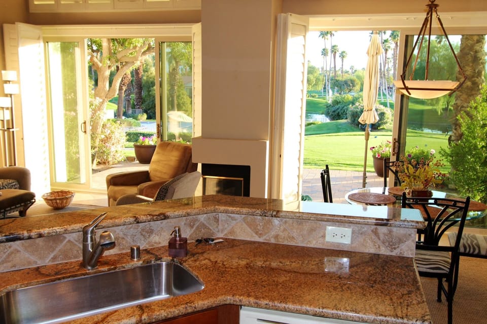 Kitchen looking out to dining area, living room and back patio