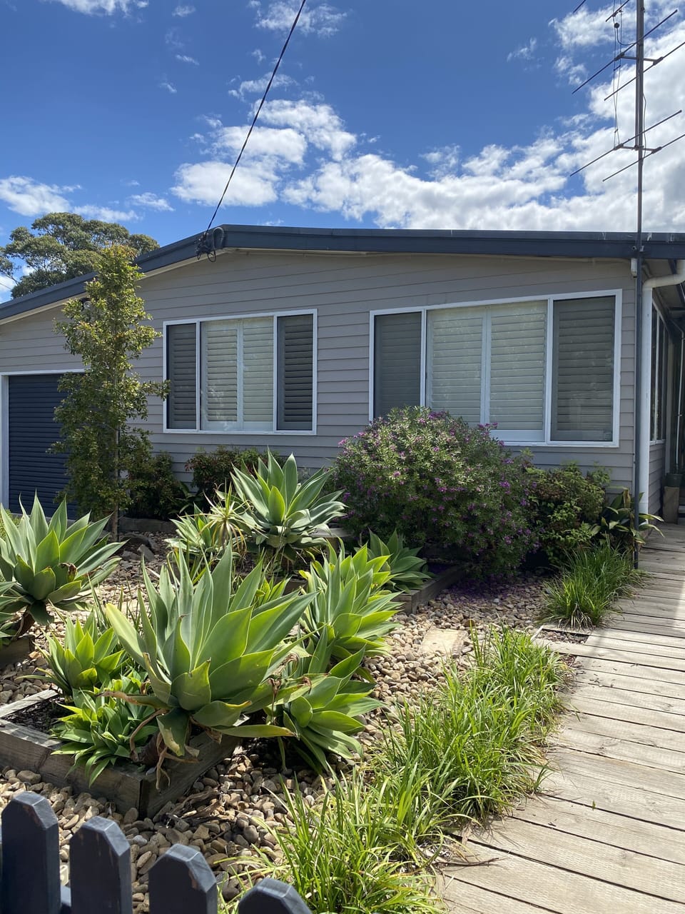 Front of house with entry from the side deck. 