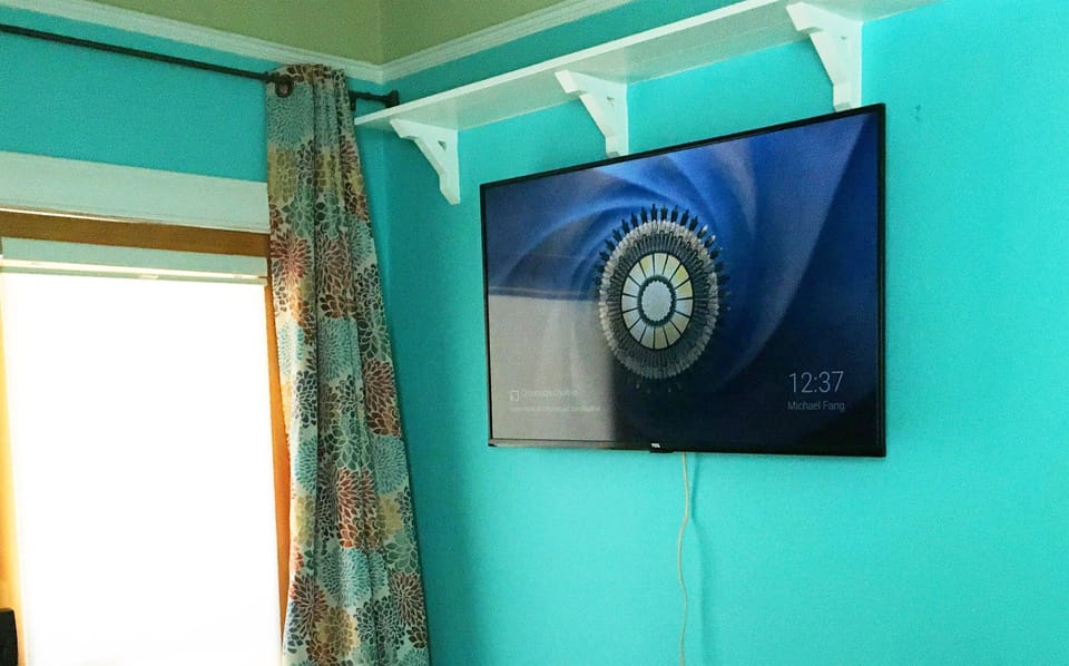 A 55-inch Smart TV graces the wall opposite the foot of the bed.