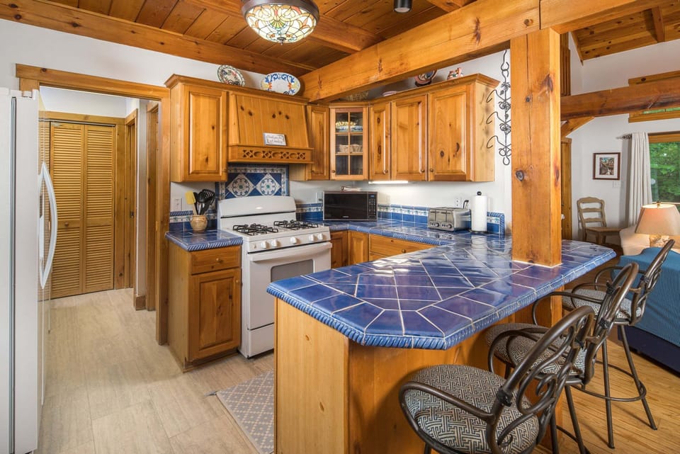 The fully stocked kitchen features ample counter space and bar seating