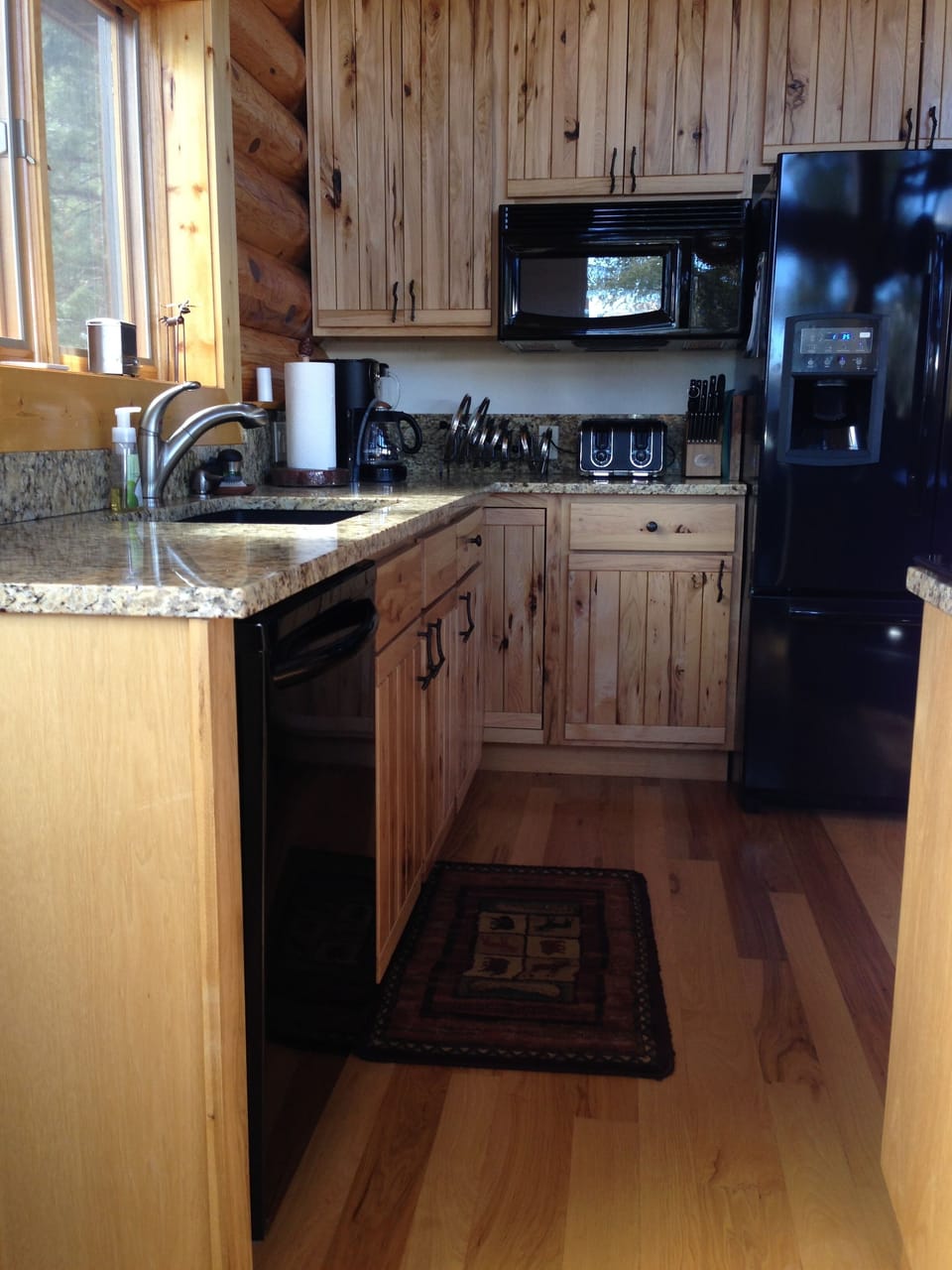 Kitchen as seen from dining area.    Window overlooks fire pit, and mountains.
