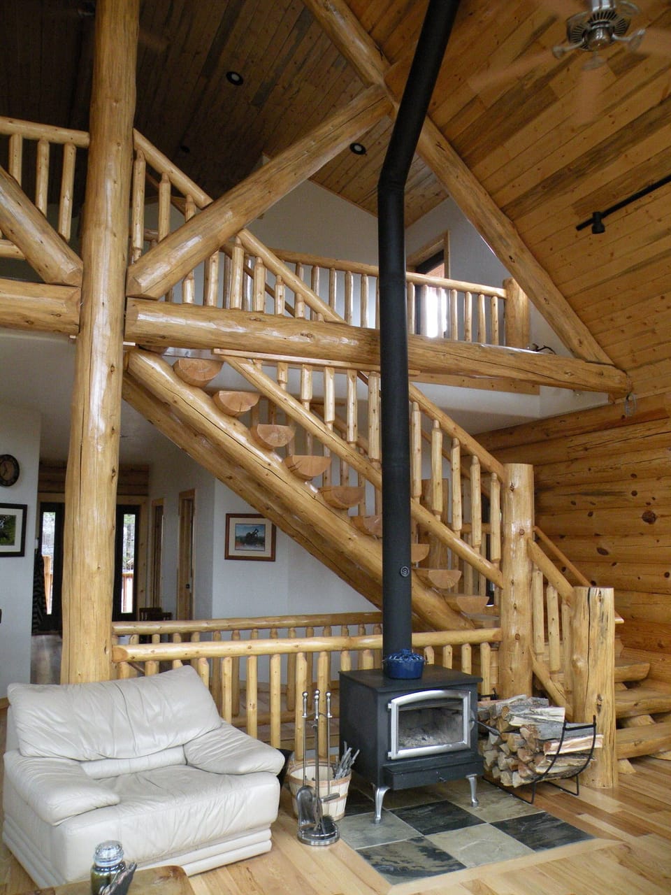 Half log stair case leads to 800 sq ft loft; Wood burning stove for chilly days.