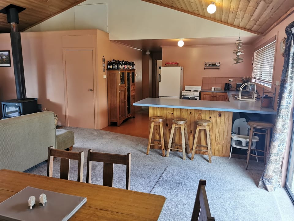Portocot and high chair under kitchen bench on right.
