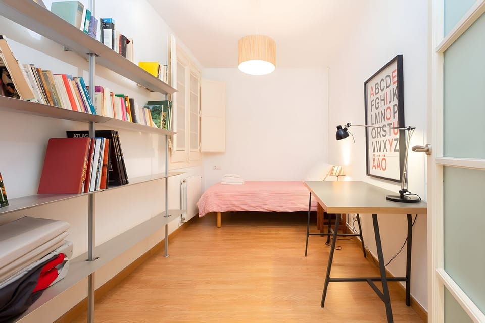 This cozy study bedroom features a comfortable single bed, a dedicated desk for work, and a bookshelf for your reading pleasure.
