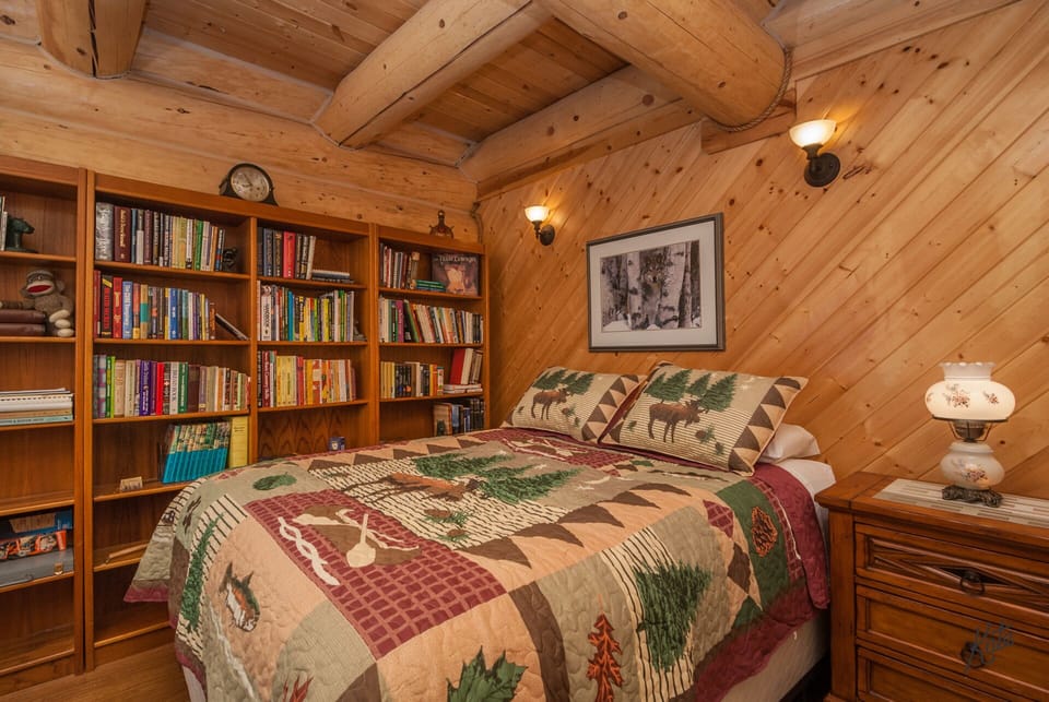 Queen bed & extensive, eclectic book collection.