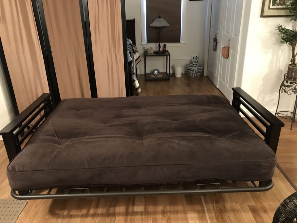 Screen separating bedroom from living room behind futon