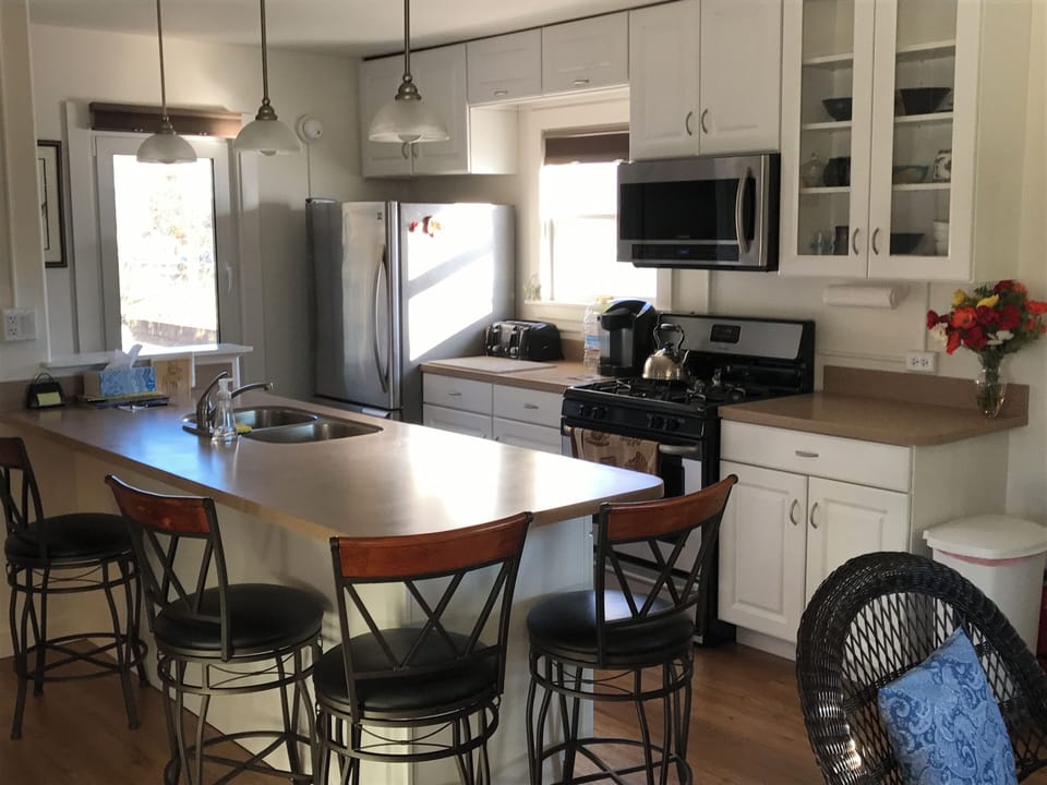 Kitchen with peninsula, counter stools and stainless steel appliances