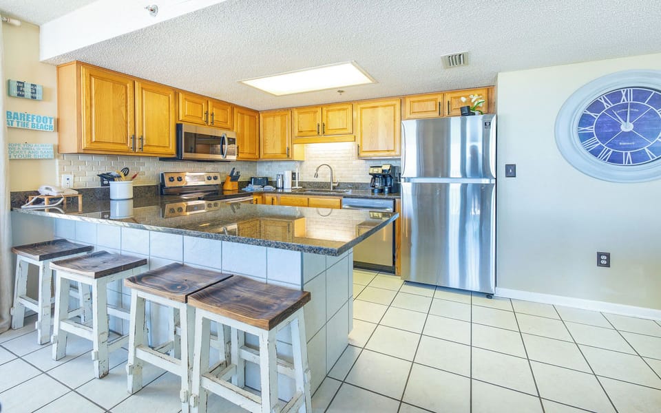 Granite counters gleam in the kitchen as you prepare a fresh brew with the coffee maker nearby