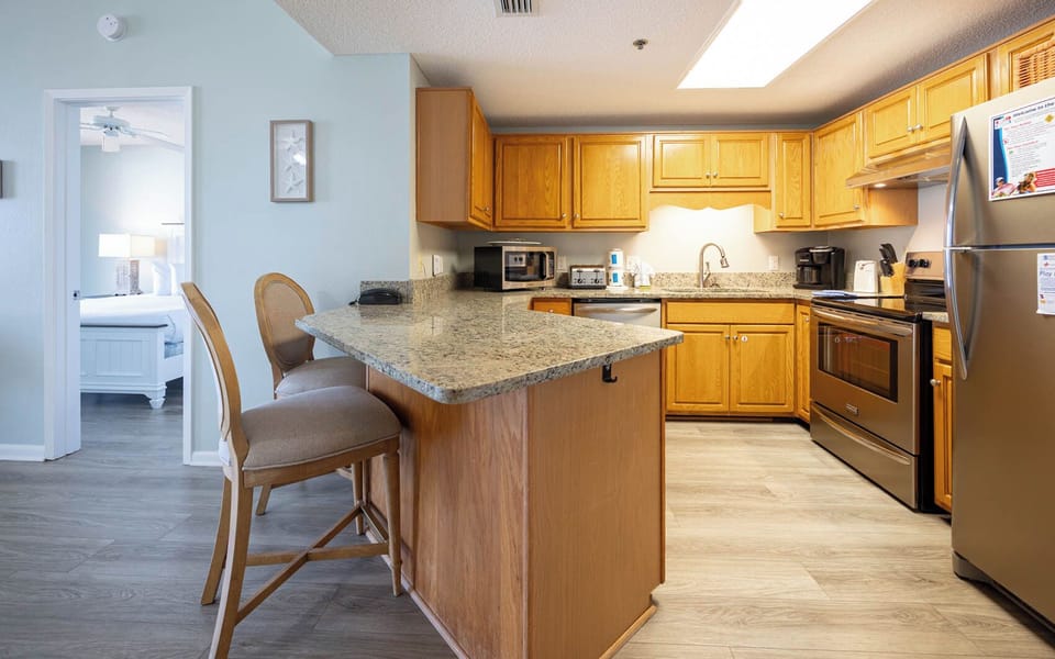 Warm wood cabinetry complements the granite countertops in this inviting kitchen area, featuring a breakfast bar with seating