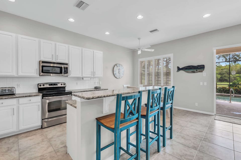 The open and airy kitchen has granite counters and stainless steel appliances