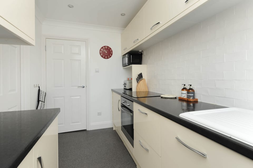 Fully equipped modern kitchen with dishwasher, hob, oven, fridge and cooking essentials