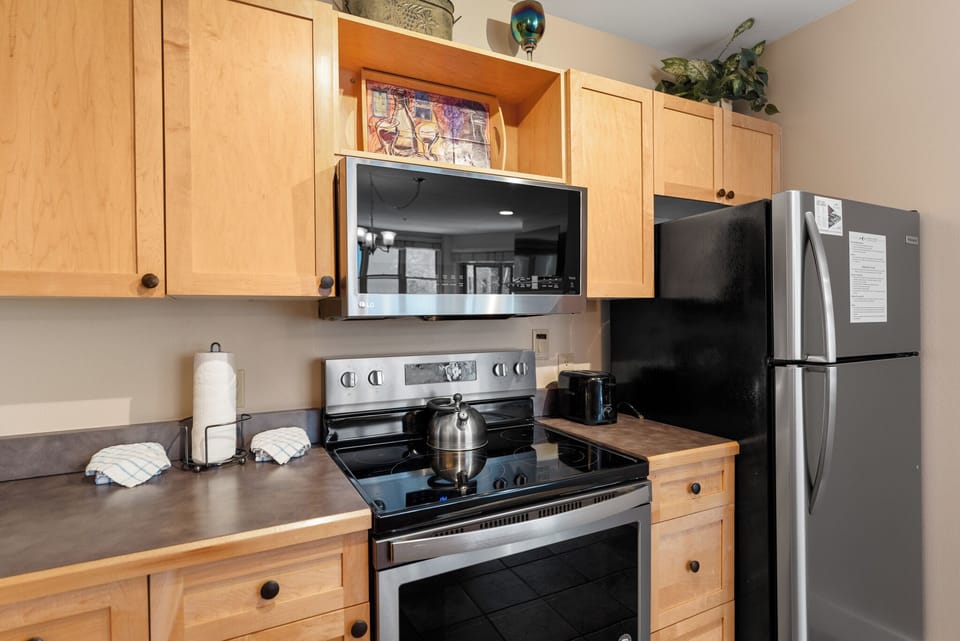 Your fully equipped kitchen features modern appliances and warm wood cabinetry, perfect for preparing meals during your stay.