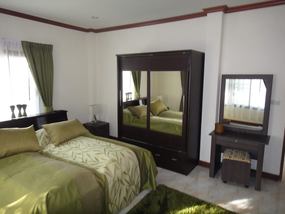 Green bedroom with TV and DVD there is access to a private toilet and bath