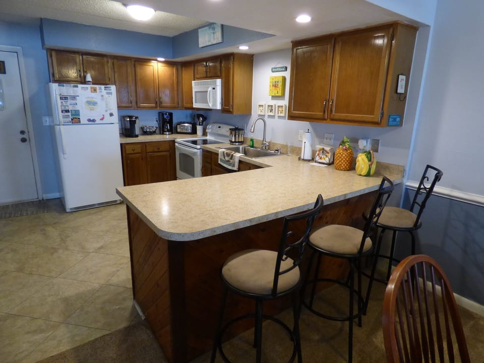Kitchen is well stocked with plenty of dishes, pots and pans, and more.